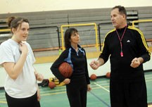 Oilfields Driller coaches Randy Heidebrecht and Barb Binkley discuss a practice drill with post Rebecca Tucker on March 15. The Drillers played in the 2A Senior girls&#8217;