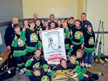 The Okotoks Peewee 3 Oil Kings celebrate with their Central Alberta Hockey League championship banner after defeating Claresholm in the league finals.