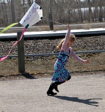 Georgia Carter tries to get her just hand-made kite up in the air at the Okotoks Art Gallery on Sunday.