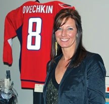 Yvonne Small poses in front of the signed Alexander Ovechkin Washington Capitals jersey she donated to the Flames Alumni Game and Gala auction to raise money for the Dunbow