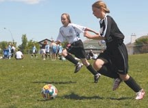 Serena King chases down Esther Forseth at the season wind-up for Okotoks Minor Soccer on June 26, 2010. The OMSA continues to advocate for an indoor facility in order to