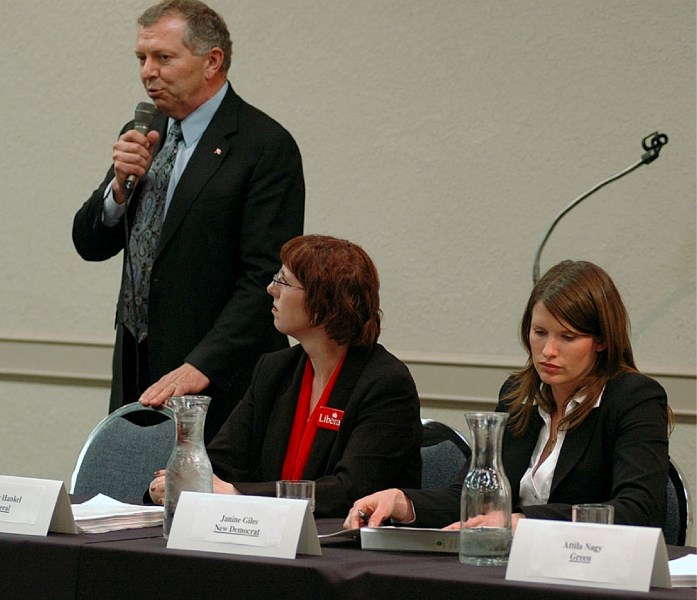 Conservative candidate Ted Menzies speaks during an election forum in High River on Tuesday evening while Liberal candidate Nicole Hankel and NDP candidate Janine Giles