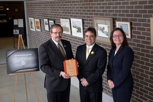 Alberta Lung Association president Leigh Allard, right, presents Okotoks Mayor Bill Robertson, left, and Coun. Stephen Clark with the group&#8217;s Iron Lung award for the