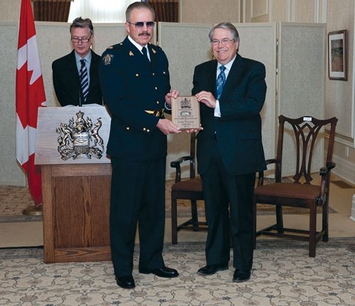 Turner Valley RCMP auxiliary constable Lyn Michaud accepts his 2011 Alberta Solicitor General and Public Security Crime Prevention Award from Minister Rob Renner.