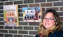 An Okotoks artist big on her local community, Erica Neumann, poses with works from The Painted Promise show. The Art in the Hall exhibition, featuring images of notable local 