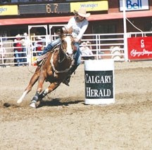 Lauren Byrne of Okotoks prepares to turn a barrel at the Calgary Stampede on July 10. Approximately 10 minutes later, her husband Jesse was out in the arena to fight bulls.
