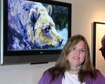 With one of her own pictures on display, Erica Neumann demonstrates how a flat panel screen can be a personal art gallery. The Okotoks wildlife painter&#8217;s web site