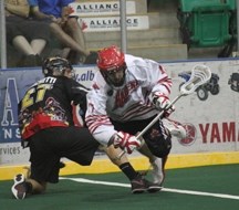 Okotoks Raider Aaron Tackaberry, right, steps over Whitby Warrior Adrian Sorichetti Aug. 24 at the Centennial Arena in the Minto Cup semifinal game. The Raiders were ousted