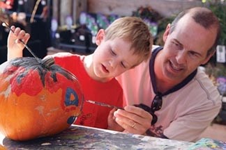 Benjamin Kelba left and his father Tim customize a pumpkin last October at Kayben Farms. The third annual Scarecrow and Pumpkin Festival comes to downtown Okotoks Saturday