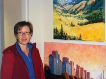 Cayley artist Estelle Selin is captured alongsider a pair of her rural themed works at Okotoks Art Gallery October 6. The experienced painter takes a moving target approach