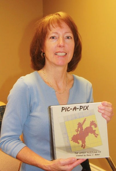 Okotoks resident Diane Baher shows off a copy of her recently published puzzle book, &#8220;Pic-a-Pix.&#8221;