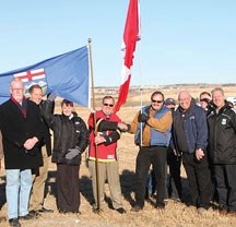 Bruce campbell/OWW MD reeve Larry Spilak waves the provincial flag while Okotoks Mayor Bill Robertson unveils the Canadian flag at the site where a $20 million fieldhouse is