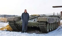 Priddis volunteer firefighter Jason Eastwood stands next to the chassis from a Russian tank he is modifying to be capable of fighting wildfires head on.