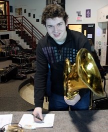 Foothills Composite High School band student Richard Charlton inspects a baritone saxophone before it is sent to Dominica. Schools from Foothills School Division have donated 