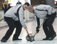 Team Libbus second Brad MacInnis, left, and third Mike Libbus sweep during the Southern playdowns on Jan. 22. The Black Diamond rink qualified for the Alberta Men&#8217;s
