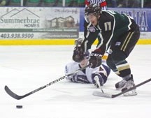 Okotoks Oilers forward Greg Lamoureux reaches for the puck as Calgary Mustang defenceman Joseph Mahon stretches out to block a shot during the second period of the