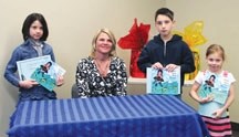 The winning authors of the Family Literacy Day committee story writing contest pose with author Corinne Finnie, middle, at the Okotoks Public Library on Jan. 27. The winning