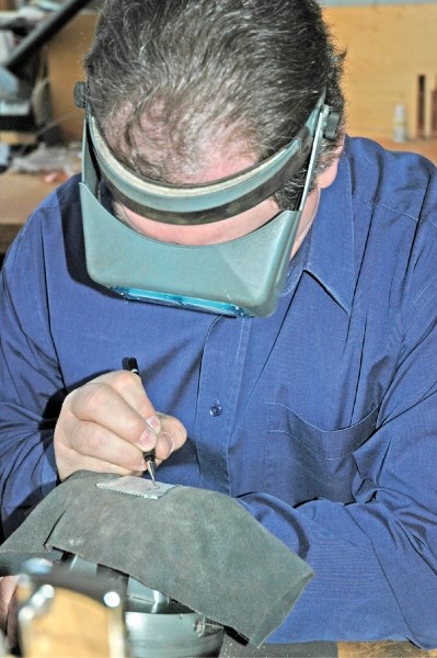 Artist Scott Hardy works on a silver buckle at his studio near Longview.