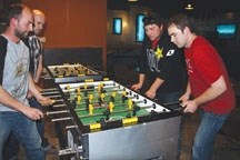 The founders of the Foothills Foosball Federation play a game at the Grand Central bar in Okotoks. They are, from bottom left, Paul Teskey, Andy Court and Brandon LaGrange.