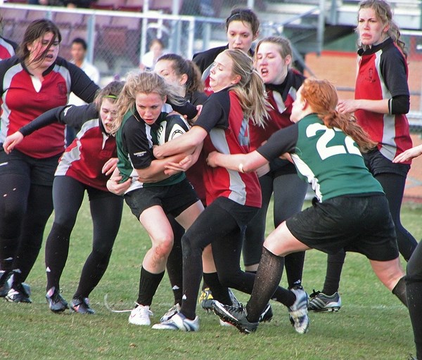 Holy Trinity Knight Jacquie Fraser, with ball, tries to break a tackle while Morgan Schultz attempts to strip the ball in a Big Sky Girls&#8217; Rugby Union game on May 2.