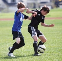 Holy Trinity Academy Knight Felix Hoppe fights for possession of the ball with a Highwood Mustang during the Knights&#8217; 2-1 win, May 16 at the Highwood High School soccer 