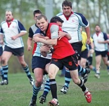 Foothills Lions winger Dustin Peterson fights through a tackle from a Calgary Canuck during Division III action between the clubs, May 25 at the Holy Trinity Academy field in 