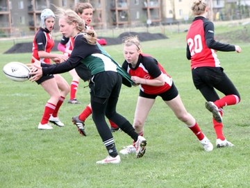 Holy Trinity Academy Knight Jacquie dishes off the ball in their 45-7 victory over the Chestermere Lakers on May 24.