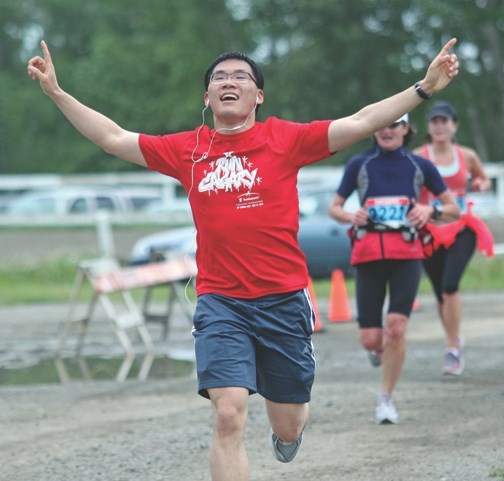 A runner celebrates his arrival near the finish line at the Millarville racetrack during the Millarville Run to the Farmers&#8217; Market Half-Marathon on July 16.