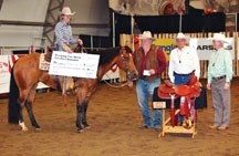 Suzon Schaal on top of Genuine Brown Gal is presented with a $2,310 cheque for winning the non-pro bridle division at the working cow horse competition at the Calgary