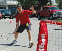 Okotoks Tennis Club president David Dam takes part in a demonstration of the sport in a parking lot in downtown Okotoks during the First Saturday festivities on Aug. 4.