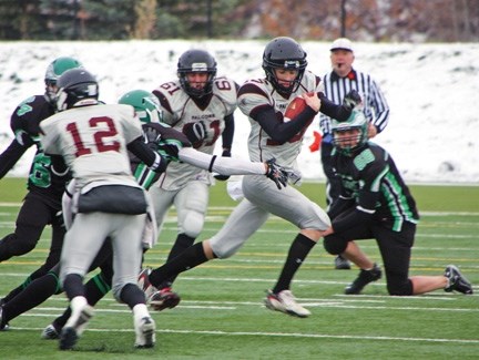 Foothills Falcon Hunter Karl slips through a tackle as Taylor Armsworthy (12) makes a block on a Springbank Phoenix during the Falcons&#8217; 17-10 loss in their playoff