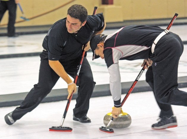 Brad MacInnis and Peter Keenan, the second and lead for Black Diamond&#8217;s Mike Libbus rink, sweep during the B-final of the Oilfields Men&#8217;s Bonspiel on Dec. 2.