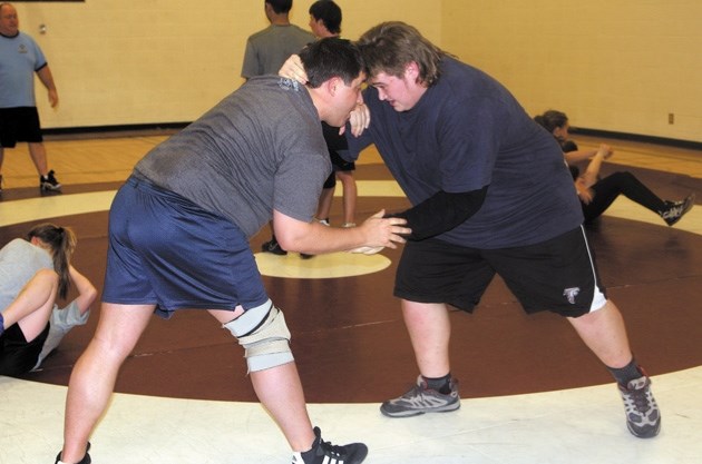 Foothills Falcon Ben Myers wrestles with coach Kelly Delanoy, right, at a Okotoks Wrestling Club practice Thursday at Foothills Composite High School.