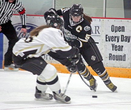 Okotokian and captain of the Rocky Mountain Raiders Amanda McLeod carries the puck through the neutral zone against the Calgary Outlaws Saturday at the Spray Lakes Sawmill