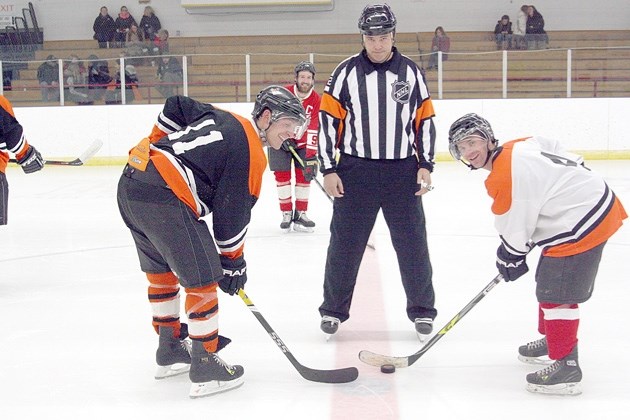 NHL referee Tom Kowal drops the puck for the final game Ollie Petersen Boxing Day tournament in High River, between Jesse Hubbard, left, and Western Hockey League referee