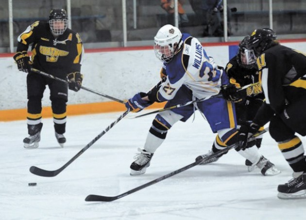 College of St. Scholastica Saints forward David Williams, an Okotoks resident, stick handles through traffic during NCAA Division III play. Williams was named conference
