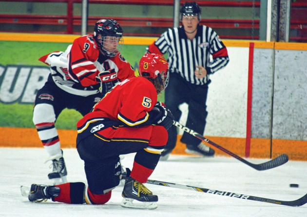 UFA Bison Brody Valette passes the puck by a Calgary Midget AAA Flames defender during Game 2 of the AMHL division quarter-finals, Saturday at Father David Bauer Arena. The