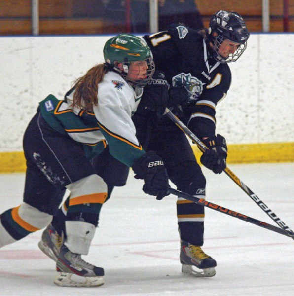 Highwood Raider forward Megan Hansen fights for the puck with a Calgary Flyer defenceman during the Raiders&#8217; 2-1 win, Saturday at the Bob Snodgrass Rec Plex in High