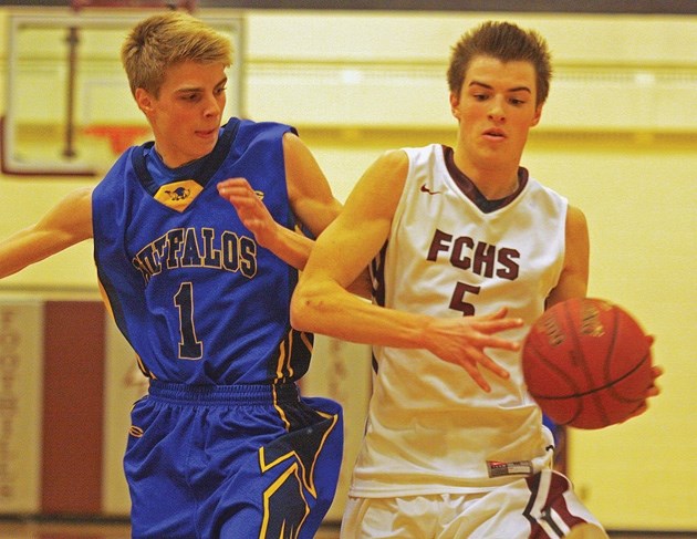 Foothills Falcon Hunter Karl (right) dribbles by Brooks Buffalos guard Cody Latrace during the South Central Zone playoffs on March 8. Karl, a Grade 11 student, joined the