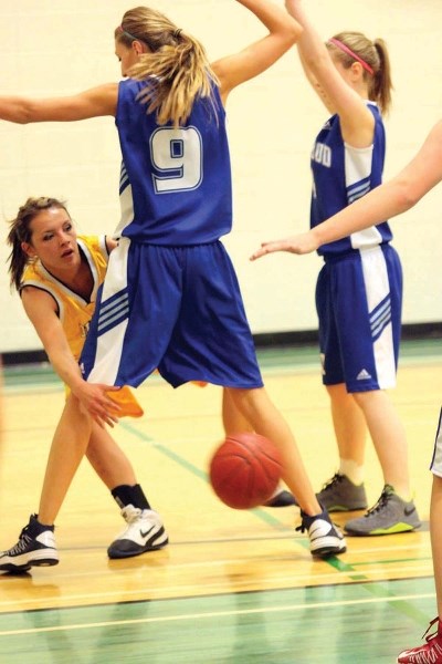 Oilfields Driller Mandy Abramson sneaks a pass around Highwood Mustang Kyra Christmas in the Foothills Athletic Council playoffs on Feb. 27. The Drillers won the 2A South