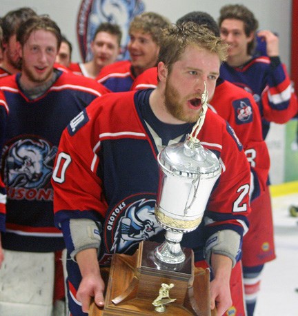Okotoks Bisons alternate captain Zach Baba takes his turn with the Heritage Junior Hockey League trophy after the Bisons won their third consecutive league championship on