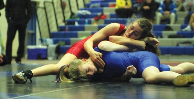 Jenna Morrison, in blue, wrestles Cassidy Barnert in the rural provincial 61kg semifinal in February at High River. Morrison is enjoying success in her first year of
