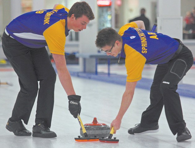 Okotoks curlers Kyler Kleibrink and Christian Sprinkhuysen, seen here sweeping at the Okotoks Men&#8217;s Bonspiel, earned a gold medal as part of Team Alberta at the