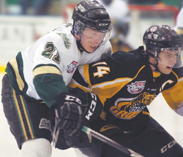 Okotoks Oiler Tariq Hammond (left) gets a hold of Olds Grizzly Bart Moran during post-season action.
