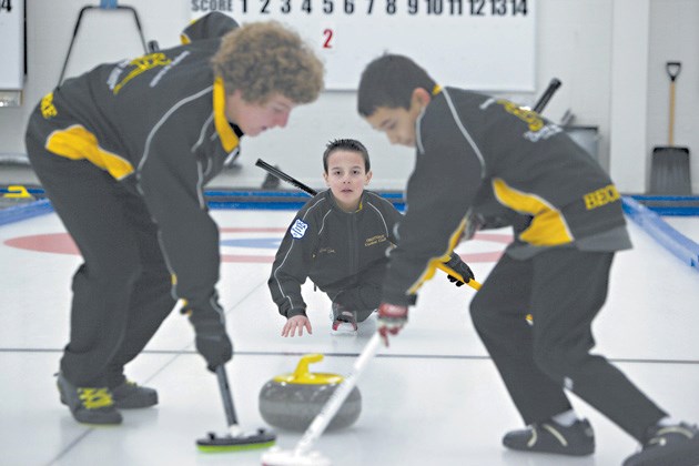 Skip Quinn Heffron throws a rock as teammates Jeremy LaBossiere and Miki Becker sweep during a training session with the Okotoks Junior Curling Academy. The Heffron-led team