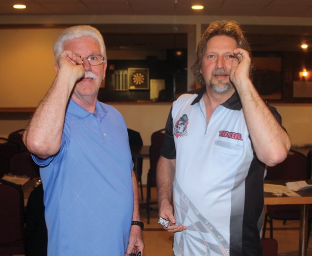 Bob Powell and Roy Andreason take aim during a night of darts at the Okotoks Elks Club on April 16. Powell and Andreason are part of Team Alberta men&#8217; s team that will