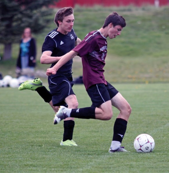 Foothills Falcon Jared Nudd is chased by Holy Trinity Academy defender Daniel Brockerville during FAC play last season. The Knights and Falcons meet on Tuesday.