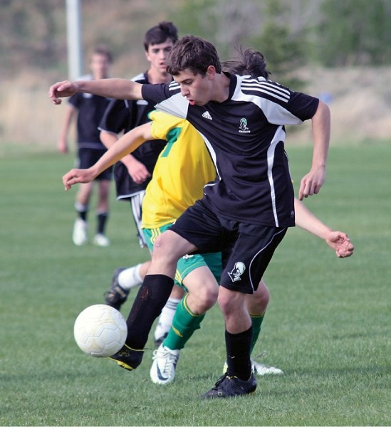 Holy Trinity Academy Knight Tulio Moraes juggles the ball in possession behind a pair of Canmore Crusaders. Moraes scored the lone goal for the host Knights in their 4-1 loss 