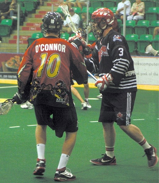 Okotoks Jr. Raider Barclay Hickey holds off a Whitby Warrior during the 2011 Minto Cup in Okotoks. The Raiders will face a tougher road to the Junior A nationals starting in