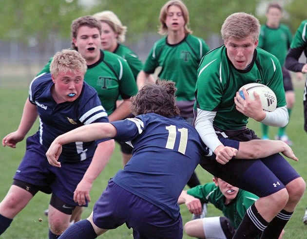 Holy Trinity Academy Knight Joel Visser slips by a Bow Valley tackler during the Knights&#8217; 27-14 win in the South Central Zone semifinal, May 22 at the Calgary Rugby